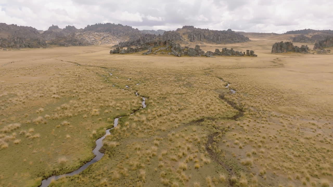 Ripresa aerea con drone di formazione rocciosa e affluente di fiume nel Perù centrale