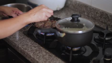 woman stirring meatballs in a skillet 24fps