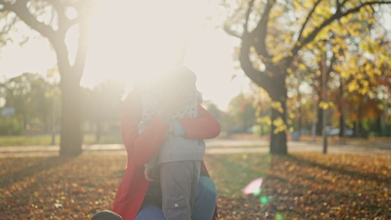 A mother and son hugging in an autumn park