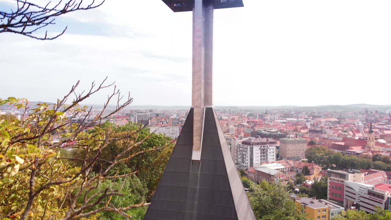 Filmagem aérea de igreja com uma cruz grande sobre cidade europeia