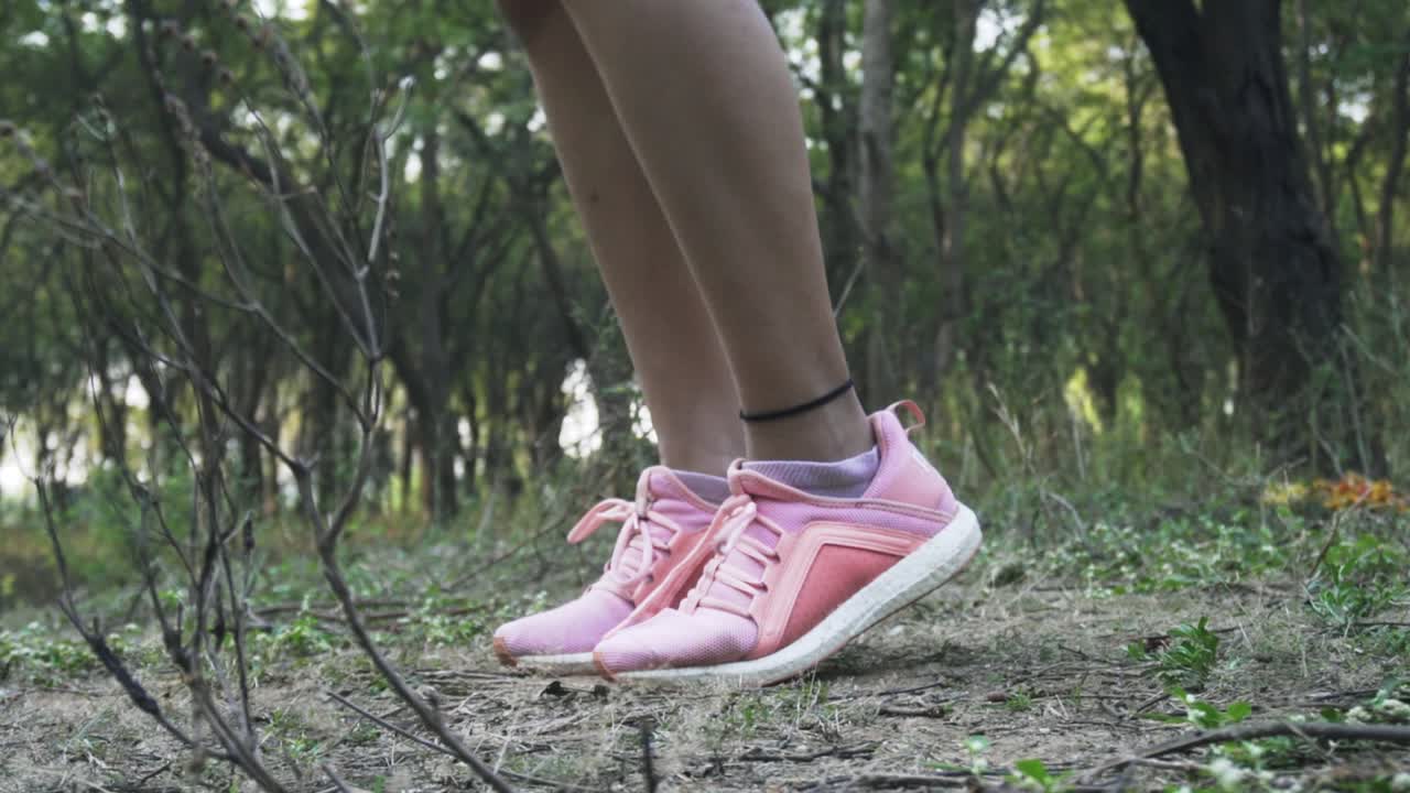 hermosa mujer atlética ejercicios con salto, saltando la cuerda en el bosque