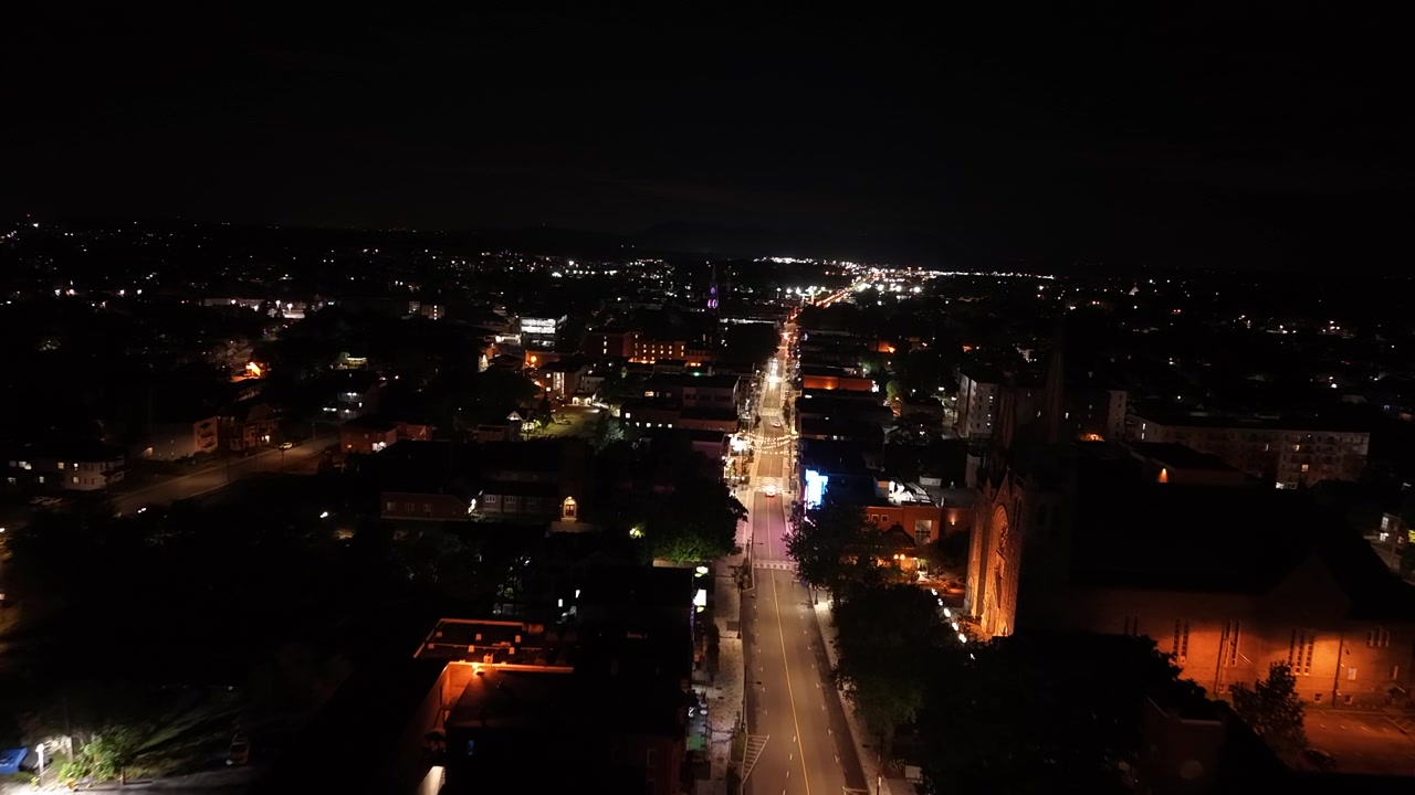 Vista aerea notturna di Via Principale nel centro di Granby, Quebec, Canada, ripresa con drone che vola lungo una strada vuota.