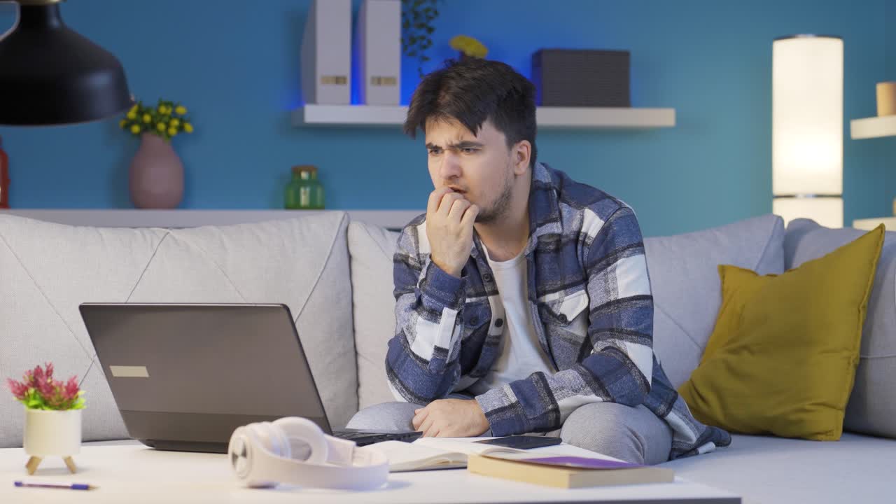 hombre mordiéndose las uñas por el estrés en casa por la noche.