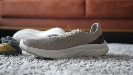 closeup of a pair of grey running shoes on a carpet