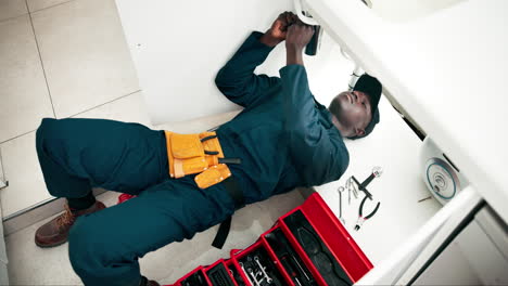 plumber working under sink