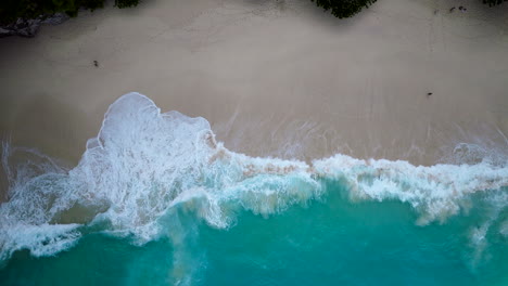 Faszinierende-Draufsicht-Per-Drohne-Auf-Die-Wellen,-Die-Auf-Bali-Auf-Den-Sand-Krachen