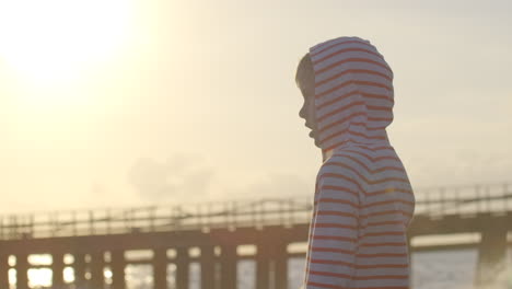 niño en el muelle del atardecer