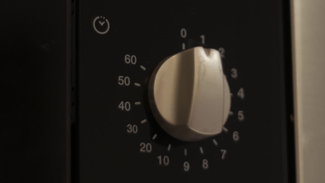 mano de persona encendiendo el microondas en la cocina