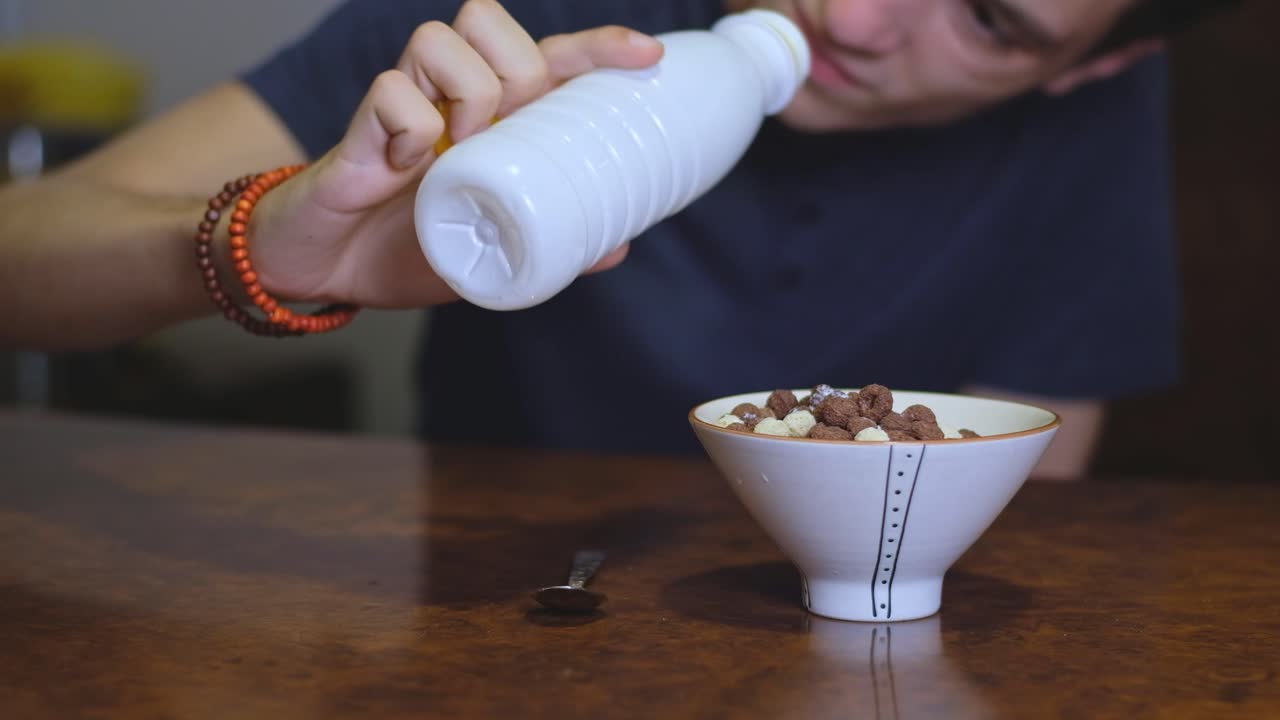 Young man is disappointed by the lack of milk for cereals. Morning situation. Daily life problems