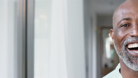 Portrait-of-happy-biracial-man-with-gray-beard-at-home,-copy-space,-slow-motion