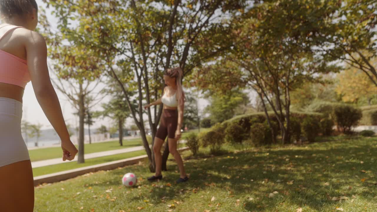 Women playing soccer in the park