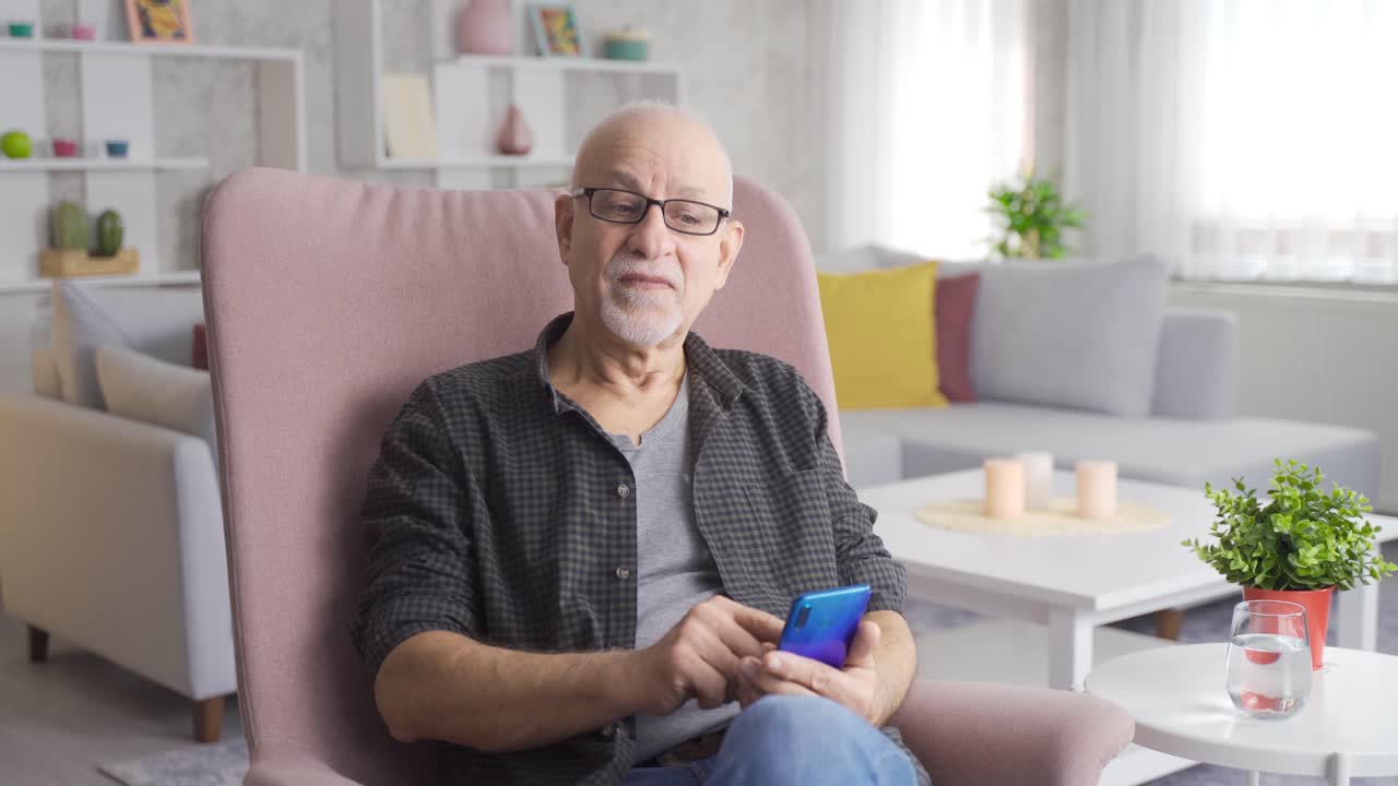 Uomo anziano felice e pensieroso che guarda qualcosa sul telefono