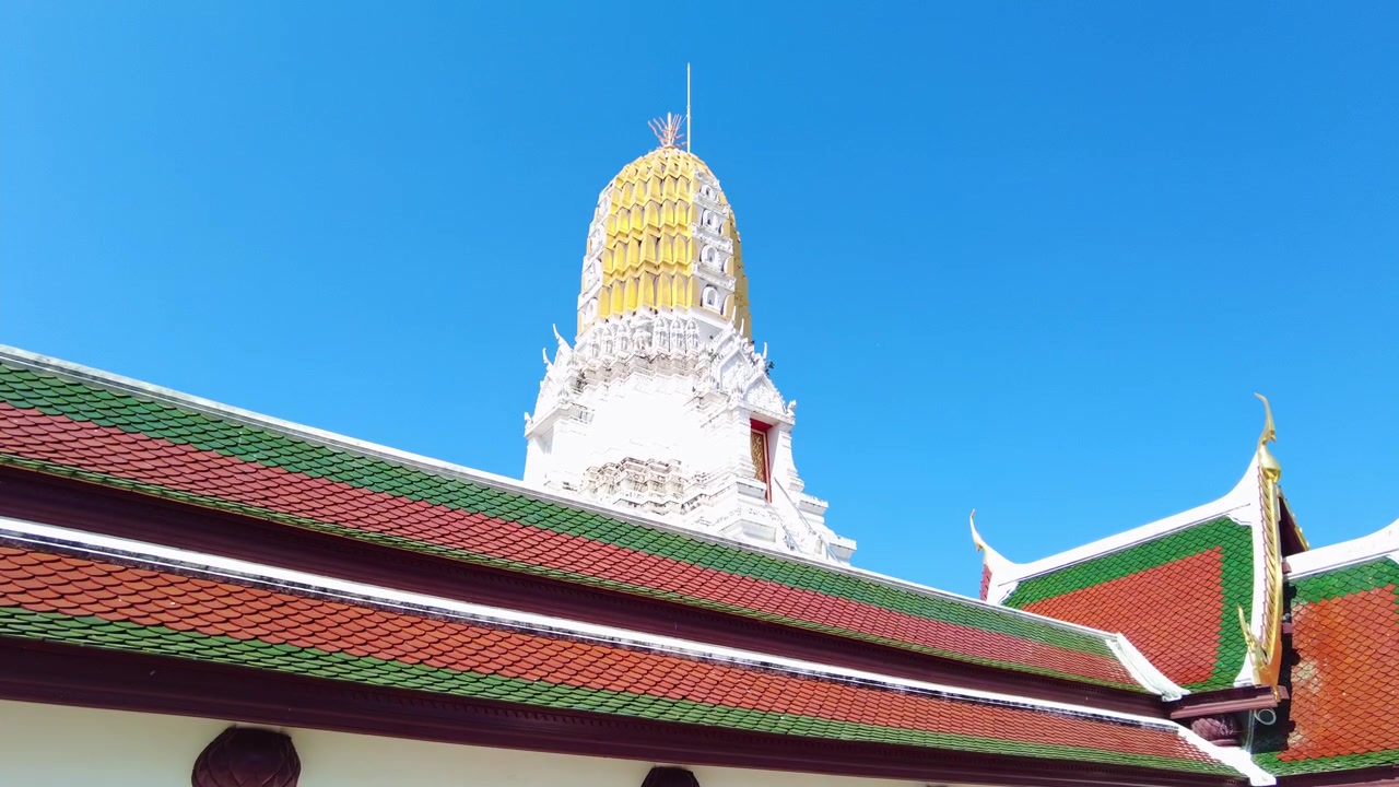 Primo piano sul tetto dorato e ornato del tempio e sull'antica torre Prang a Wat Phra Si Rattana Mahathat, Thailandia