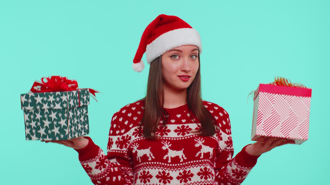 Woman in christmas red sweater santa hat smiling holding two gift boxes new year presents shopping