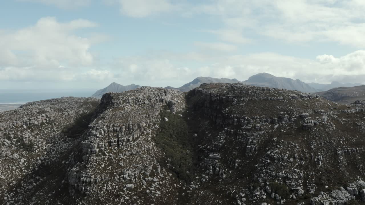 paso de montaña boscoso aéreo rastreando hacia adelante revelando la cordillera épica y el océano 4k