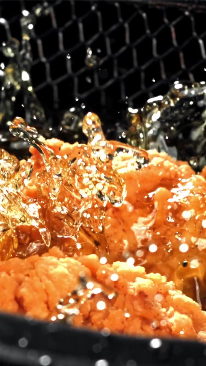 Crispy Fried Chicken Being Lowered into Sizzling Hot Oil
