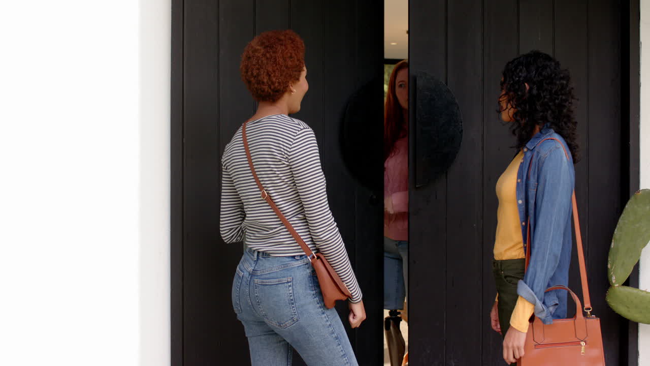 Greeting female friends at door, women hugging and smiling, enjoying hangout together