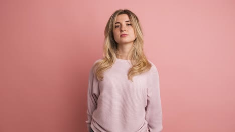 serious young woman thinking in pink studio