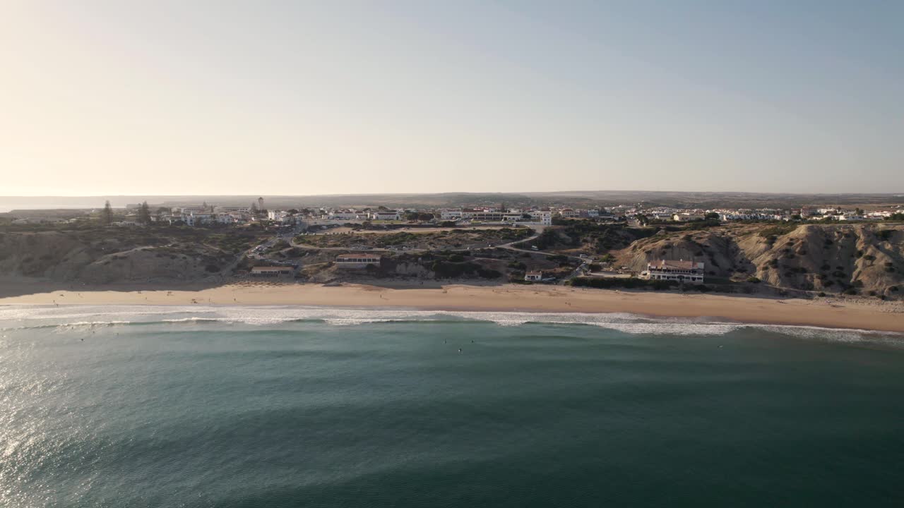 vuelo aéreo adelante bahía arenosa protegida por acantilados rocosos, playa mareta - sagres