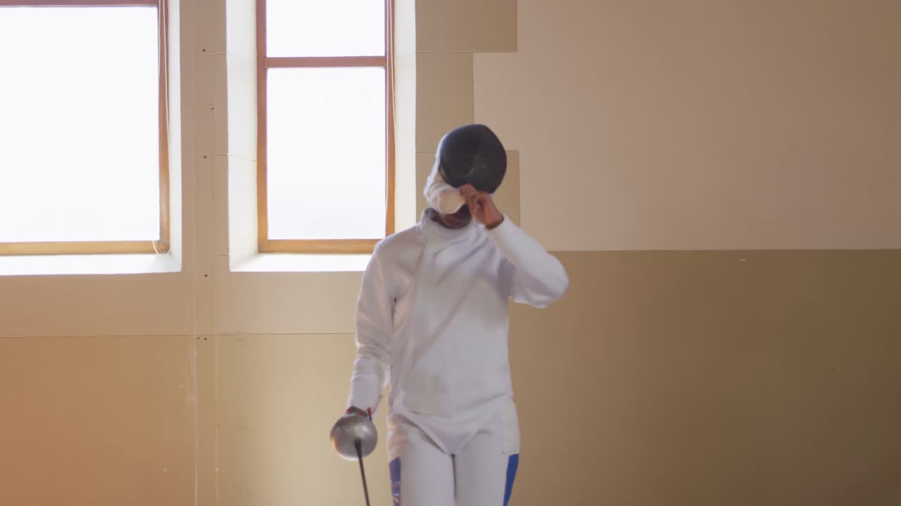 Atleta schermitrice durante un allenamento di scherma in palestra