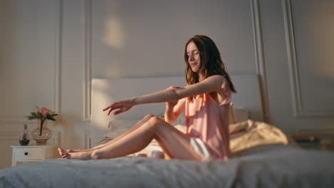 mujer aplicando crema cuerpo en la luz del sol dorado. feliz chica relajada disfrutando del tiempo