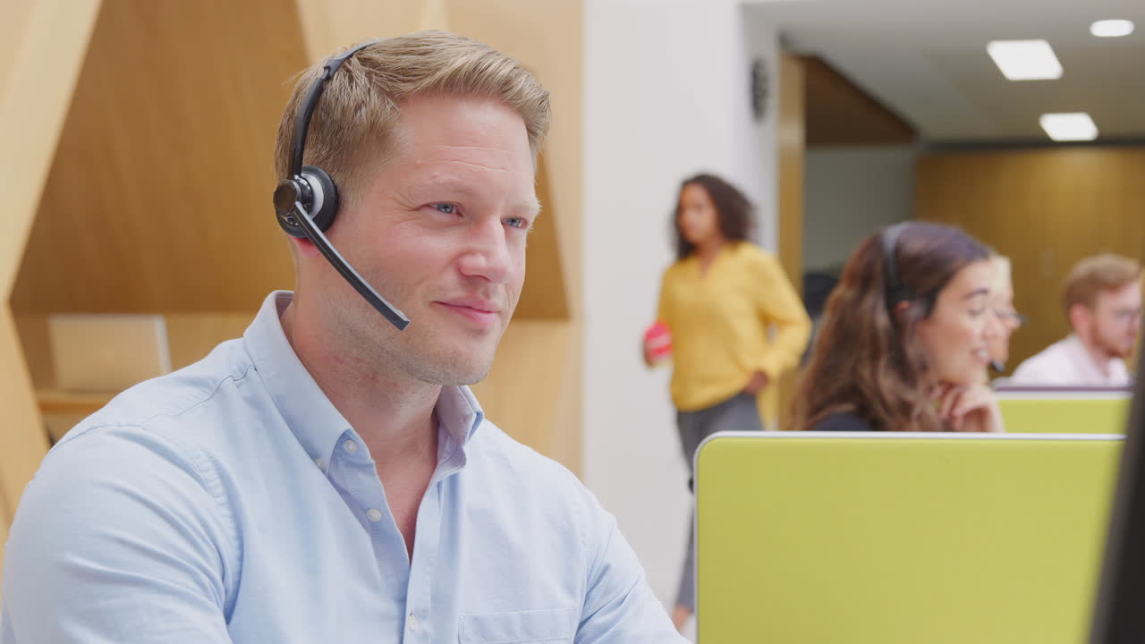 retrato de un hombre de negocios con auriculares trabajando en una computadora en un centro de servicios al cliente
