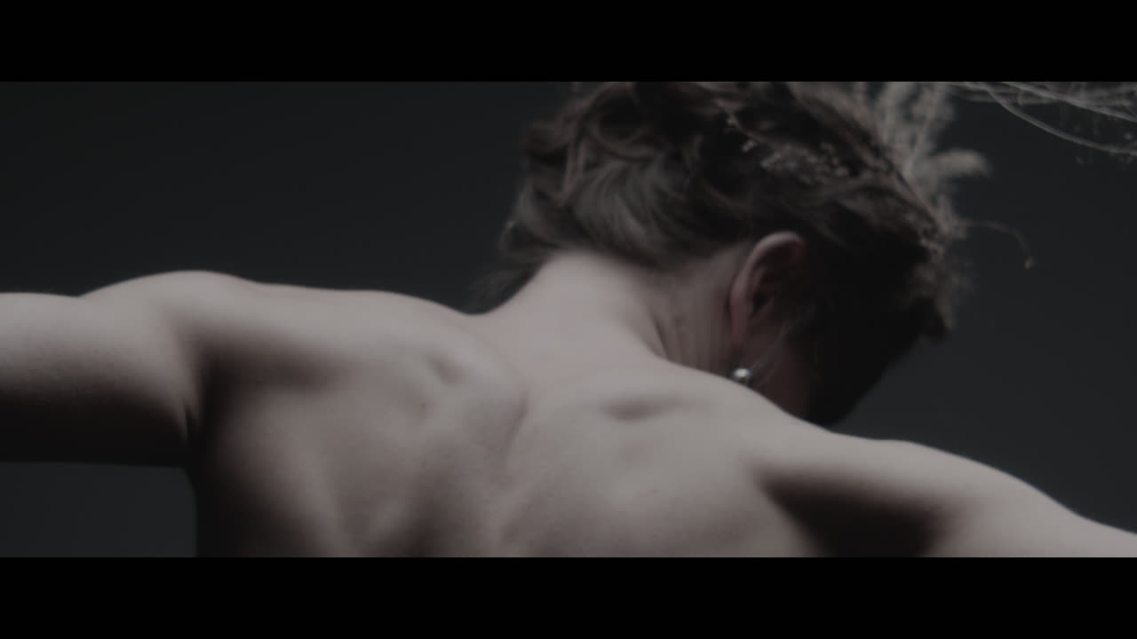 A woman dressed as mother nature moves slowly in a dance-like motion