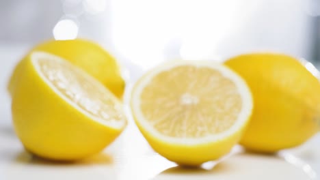 dolly in toward fresh lemons on white table, selective focus, fruit concept