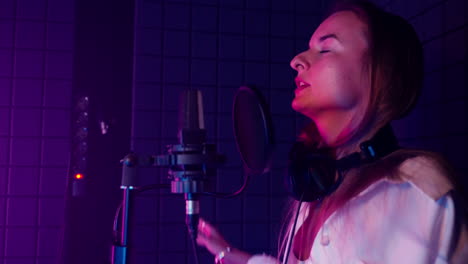 mujer cantando en un estudio de grabación