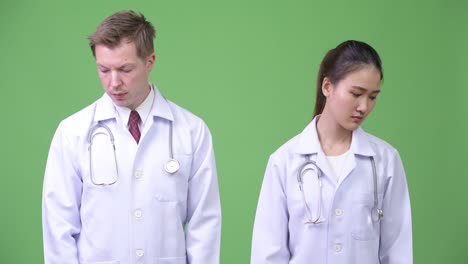 Serious multi-ethnic couple doctors thinking together