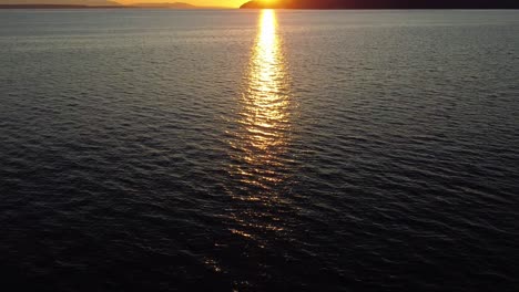 drone revealing the islands and mountains over the puget sound at sunset, washington state