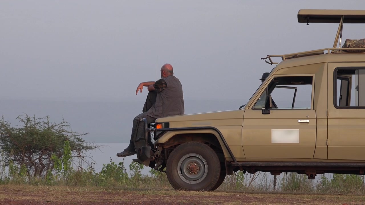 Hombre sentado en un vehículo de safari observando el paisaje