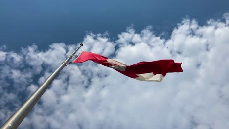 canadian flag at half mast waving on pole from below during mourning; 4k