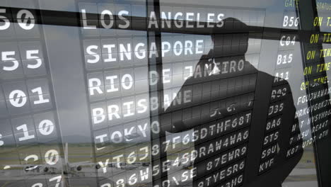 silhouette of a man looking out an airport window