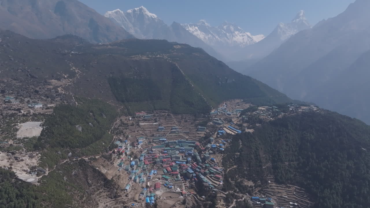 Namche village in Nepal’s Everest region, home to Sherpa community, lies on calm green hills with mountain layers and soft sunlight horizon view