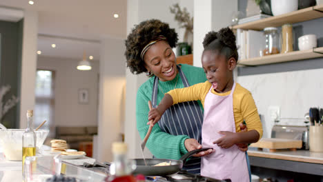 Glückliche-Afroamerikanische-Mutter-Und-Tochter,-Die-Pfannkuchen-In-Der-Küche-Braten,-Zeitlupe