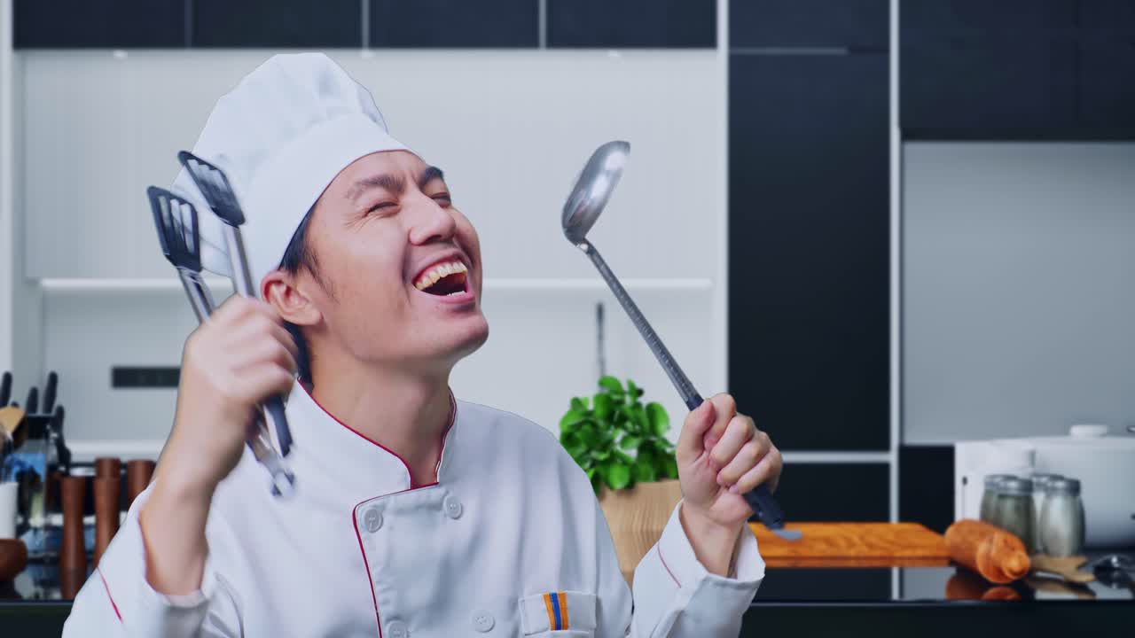 집 주방 에 서 있는 동안 질 과 비 를 들고 춤 을 추는 아시아인 요리사 의 근접 사진