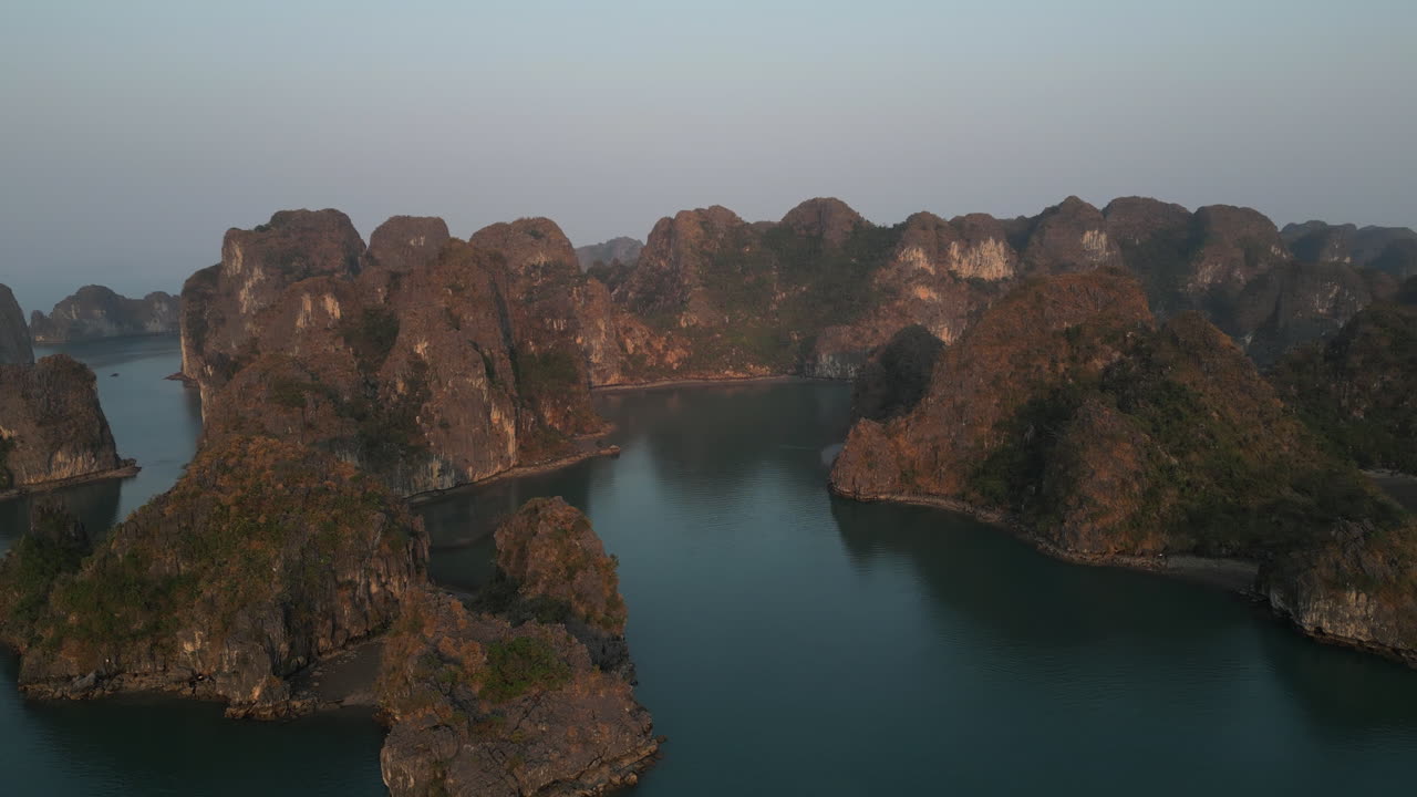 Aerial 4K drone footage over Ha Long Bay, Vietnam, showing tourist boats navigating among limestone karsts and emerald waters