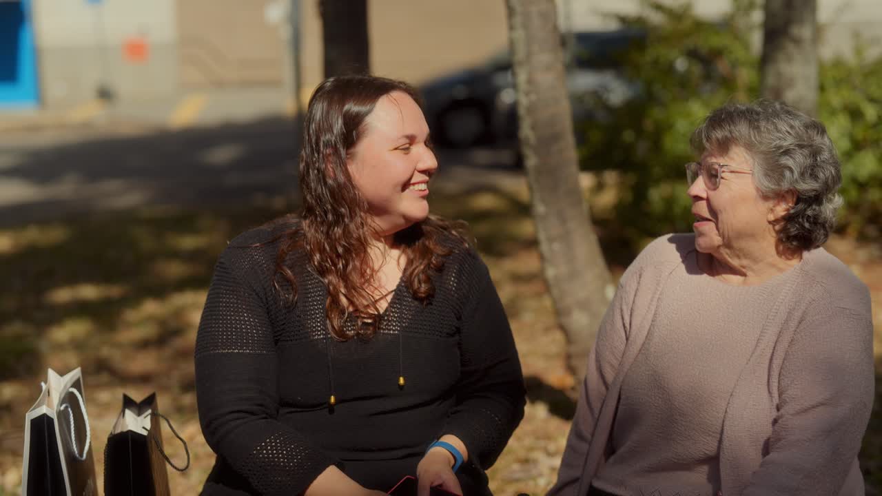 Two Women Sharing a Happy Conversation in a Park