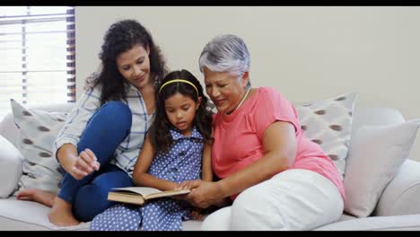 Madre-E-Hija-Leyendo-Un-Libro-En-La-Sala-De-Estar-4k