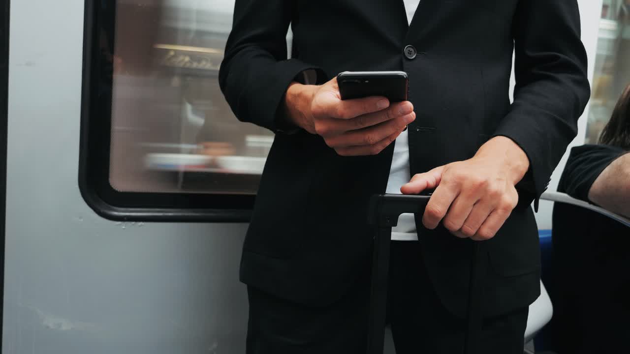 Man in suit using phone on subway