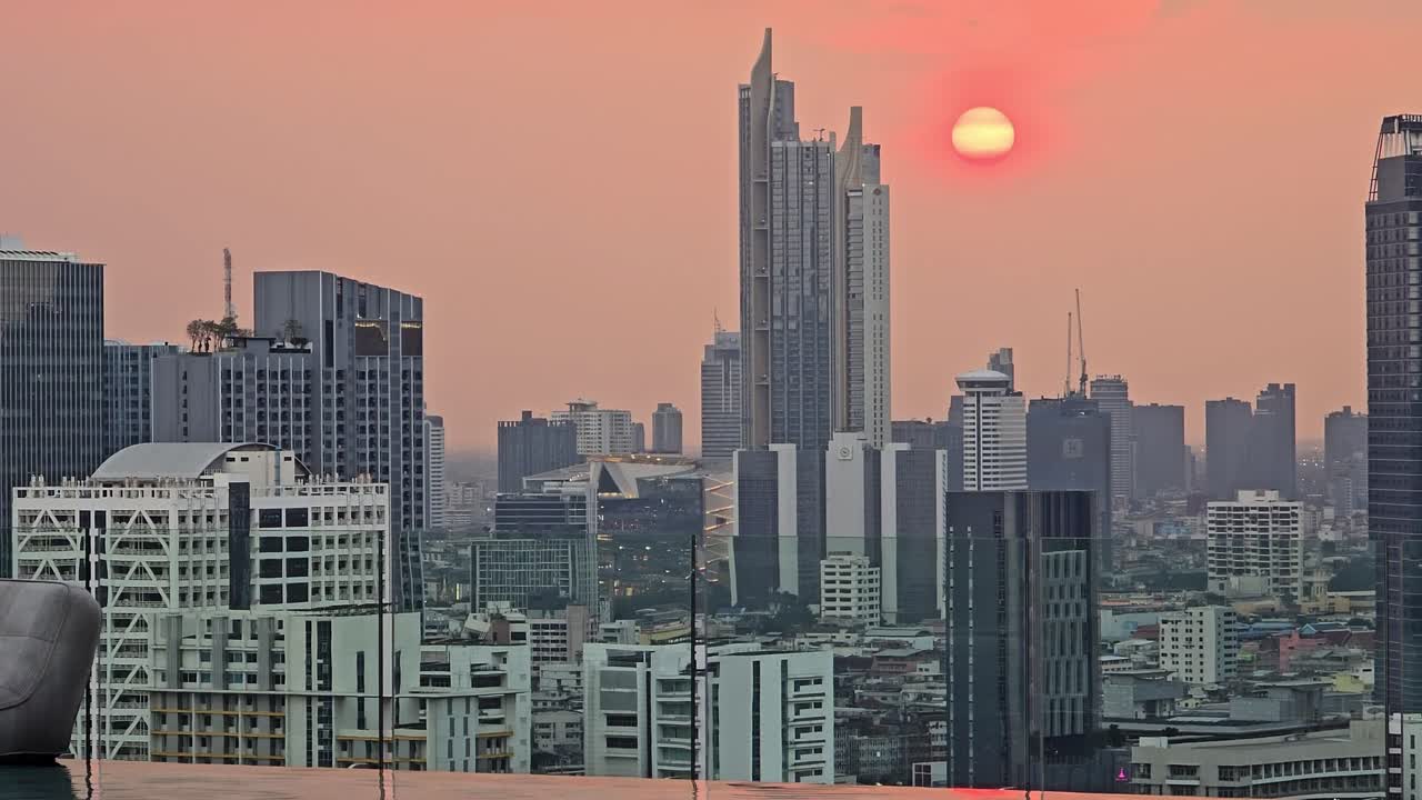 Arranha-céus da cidade de Banguecoque sob um céu rosa ao pôr do sol, com zoom
