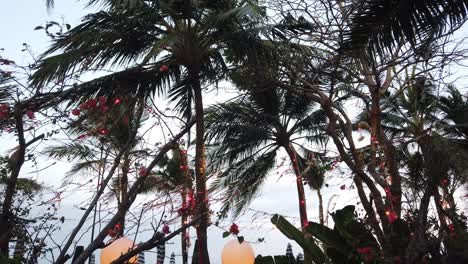 balinese palm trees landscape at sunset on the beach in sanur with beach club decoration, panoramic
