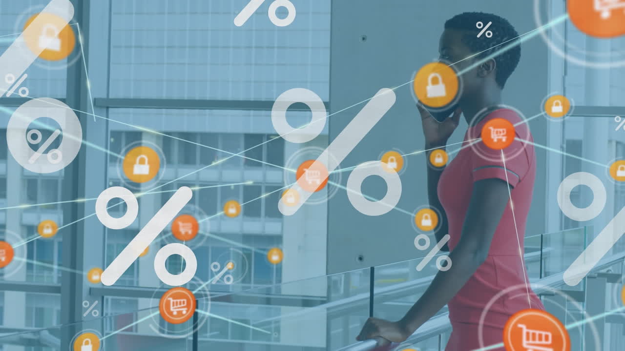 Animation von Prozentsymbolen über afroamerikanischer Geschäftsfrau, die im Büro am Smartphone spricht