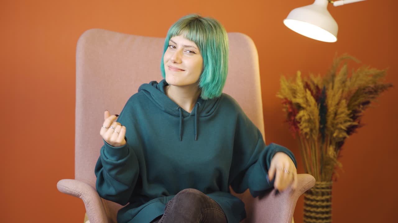 Young woman making money sign with her hands.