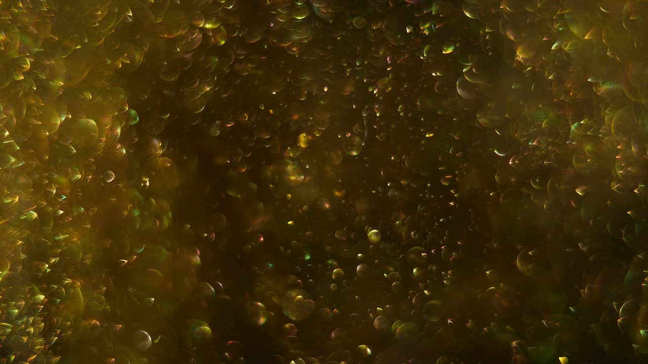 마법의 황금빛 불꽃이 회전하고 회전하며 회색과 검은색의 배경에서 무작위로 움직입니다.