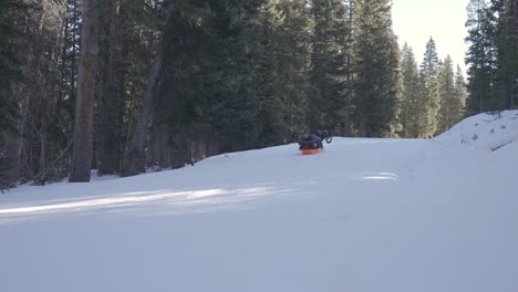 Mann-Fährt-Im-Winter-Beim-Zelten-Mit-Dem-Schlitten-Einen-Hügel-Hinunter