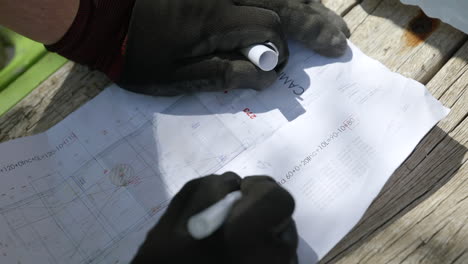 construction worker hands writing notes on property blueprint layout