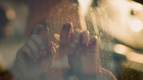 a close-up shot of a little girl inside a car, playing with her hands on the window glass. the image captures the child's hand pressing against the slightly foggy