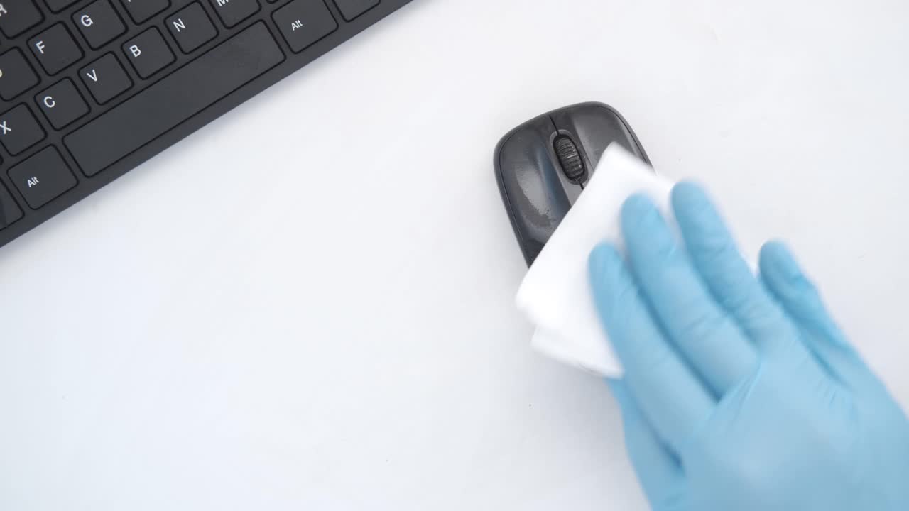 limpieza del ratón y el teclado de la computadora con guantes
